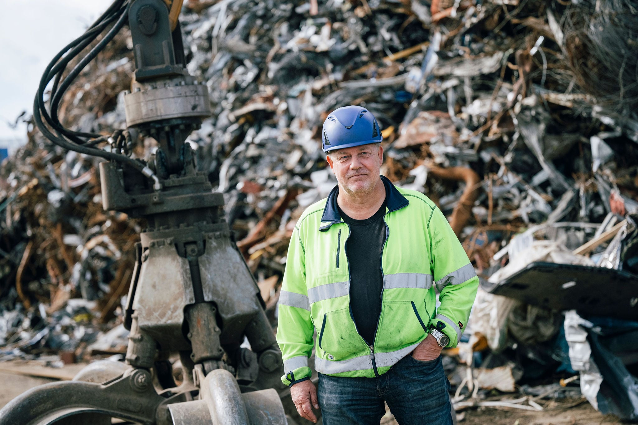 Medarbetare vid Nordic Raw Materials metallåtervinningsanläggning i Landskrona, framför en hög med återvunnet metallskrot.